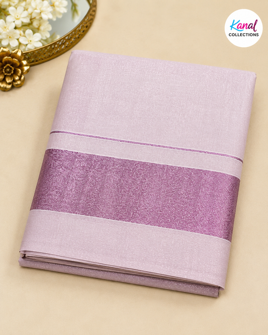 A folded light purple/lavender fabric item, likely a sari or textile, with a wide shimmering mauve-purple band across the middle, photographed on a beige surface with decorative flowers and a gold mirror edge in the corner. A 'Kanal Collections' logo appears in the top right.