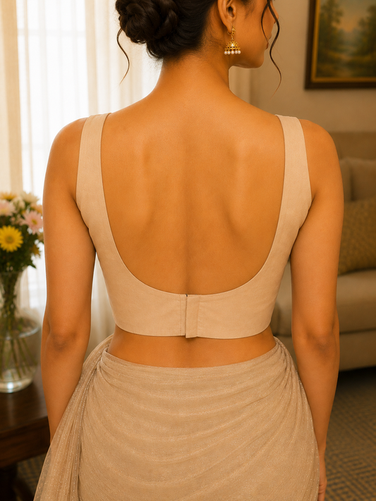 Woman wearing a beige dress with an open back in a room setting.